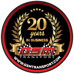 Circular anniversary badge: 20 years in business with gold laurel wreath and GSM Transport logo, black background, red border.